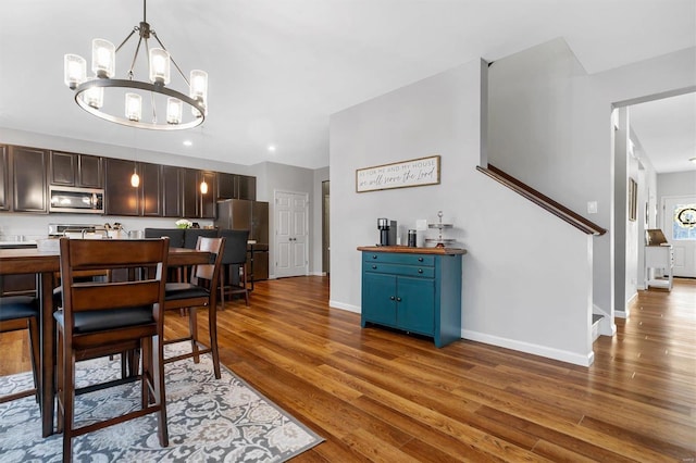 dining area with hardwood / wood-style floors and a notable chandelier