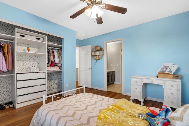 bedroom with ensuite bathroom, dark hardwood / wood-style floors, ceiling fan, and a closet