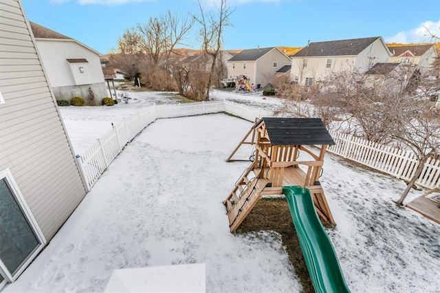 yard layered in snow featuring a playground