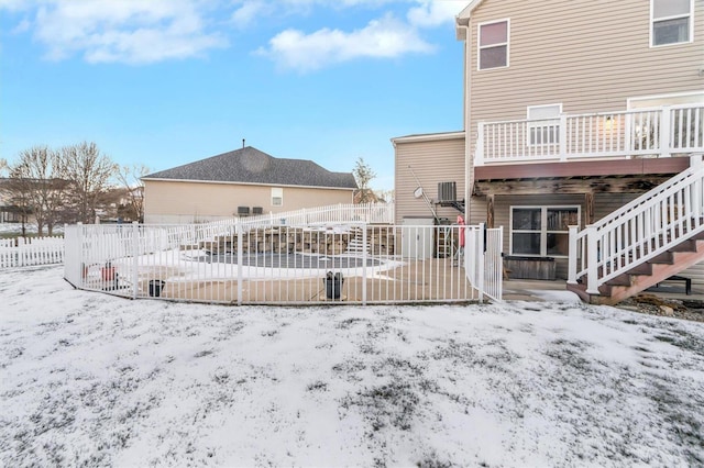 snow covered back of property featuring a wooden deck and central air condition unit