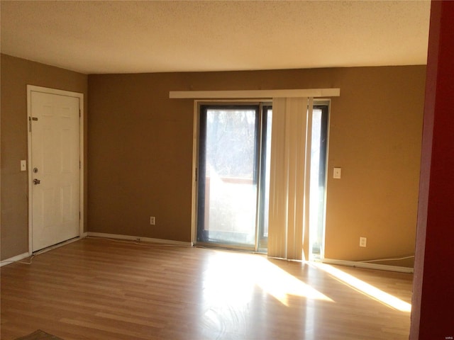 spare room with wood-type flooring and a textured ceiling