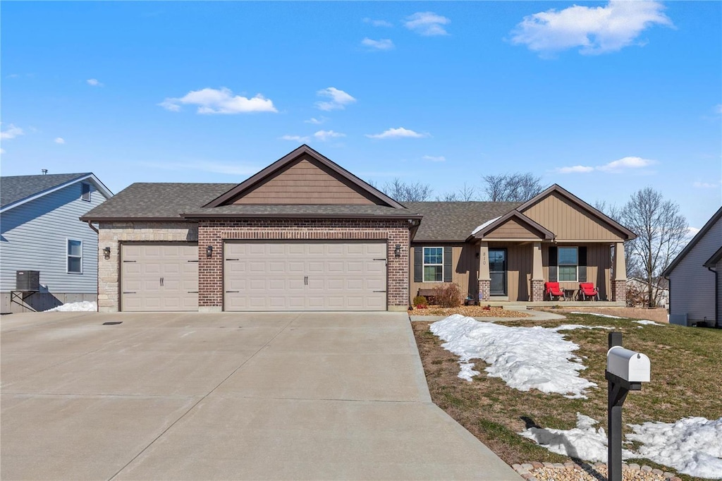 view of front of house featuring cooling unit, a garage, and a porch