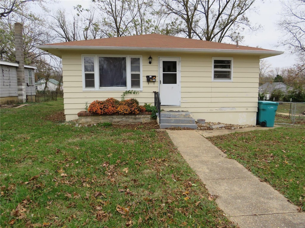 bungalow-style home with a front yard