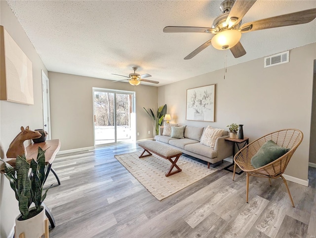 living room with light hardwood / wood-style floors and a textured ceiling