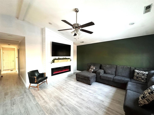 living room with light hardwood / wood-style floors, ceiling fan, and vaulted ceiling with beams