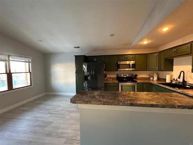 kitchen with stainless steel appliances, sink, vaulted ceiling, and kitchen peninsula