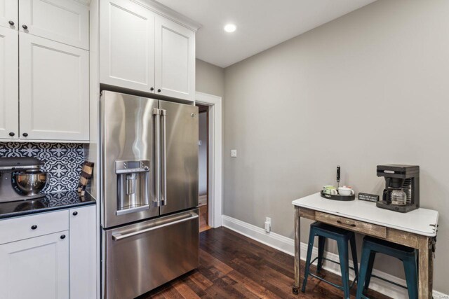 kitchen featuring baseboards, dark wood-type flooring, white cabinets, high end refrigerator, and tasteful backsplash