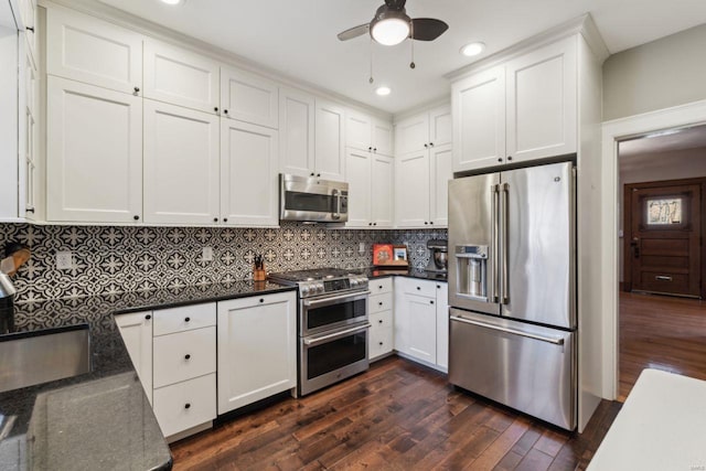 kitchen featuring a sink, backsplash, dark wood-style floors, white cabinetry, and stainless steel appliances