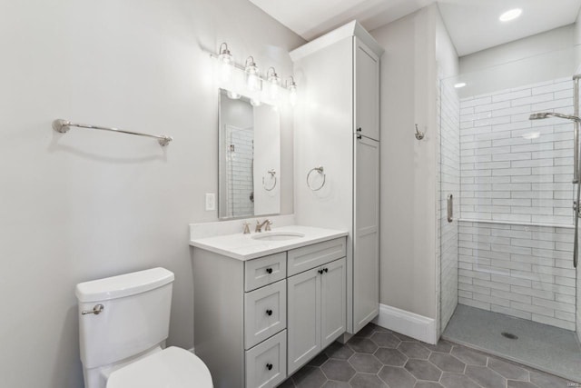 bathroom with baseboards, toilet, a stall shower, tile patterned floors, and vanity