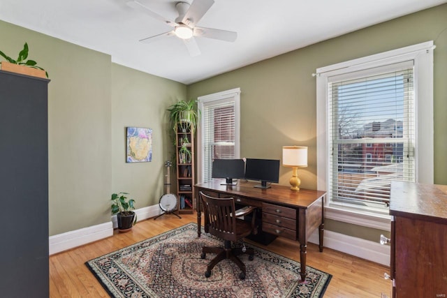 home office featuring baseboards, a healthy amount of sunlight, ceiling fan, and hardwood / wood-style flooring