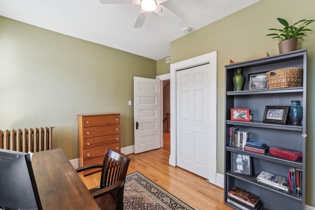 office with a ceiling fan, radiator heating unit, wood finished floors, and baseboards