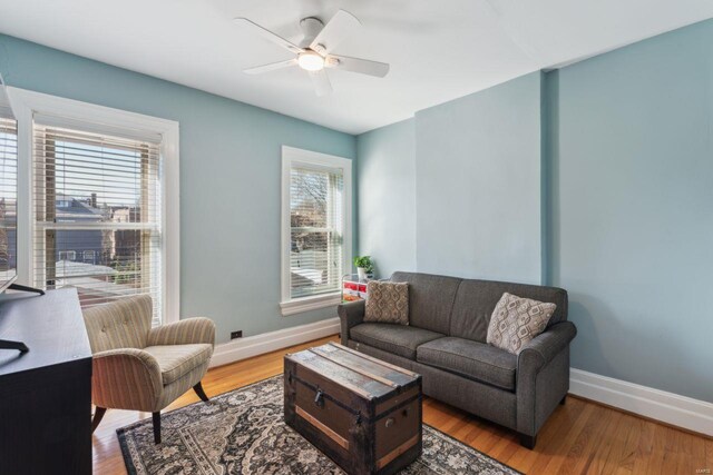 living area with ceiling fan, baseboards, and wood finished floors