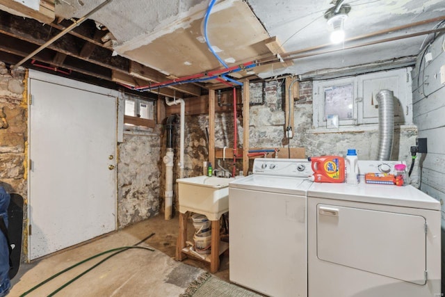 laundry room with laundry area, independent washer and dryer, and a sink