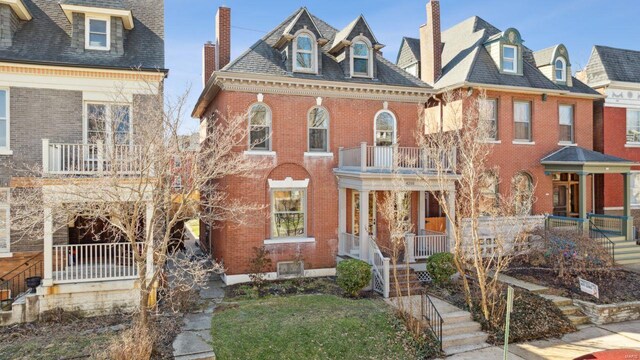 view of front facade featuring brick siding and a chimney