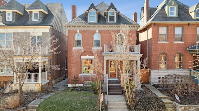 view of front of property featuring brick siding and a balcony