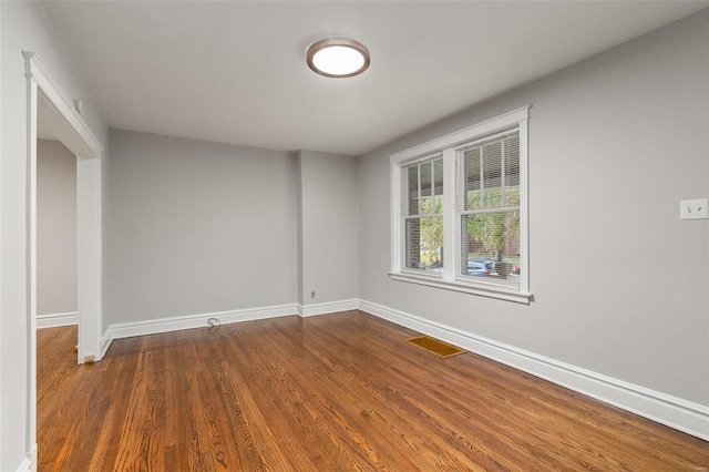 spare room featuring dark wood-type flooring