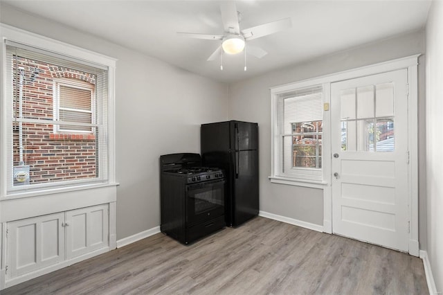 kitchen with ceiling fan, black appliances, and light hardwood / wood-style floors