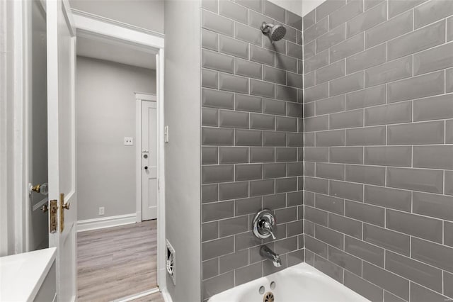 bathroom with vanity, tiled shower / bath combo, and hardwood / wood-style flooring