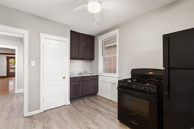 kitchen featuring dark brown cabinetry, ceiling fan, black appliances, and light hardwood / wood-style flooring