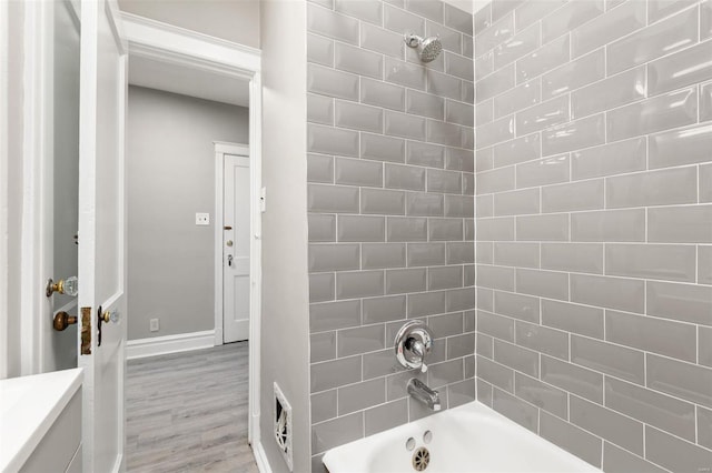 bathroom featuring vanity, hardwood / wood-style flooring, and tiled shower / bath