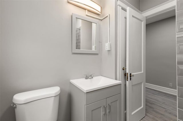 bathroom featuring toilet, wood-type flooring, and vanity