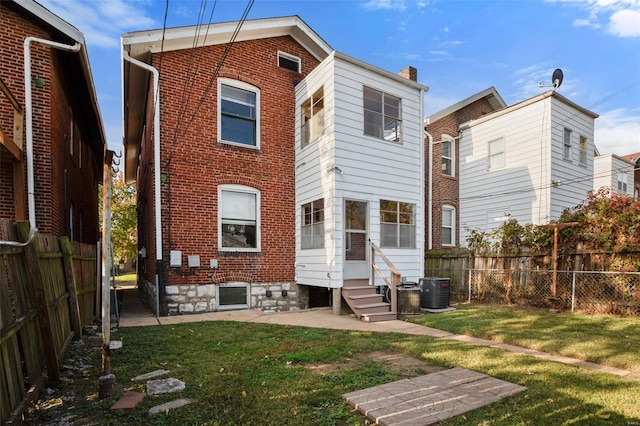 back of house featuring central AC and a lawn