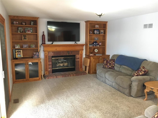 living room with a brick fireplace and carpet floors