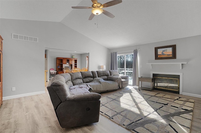 living room featuring light hardwood / wood-style floors, ceiling fan, and vaulted ceiling