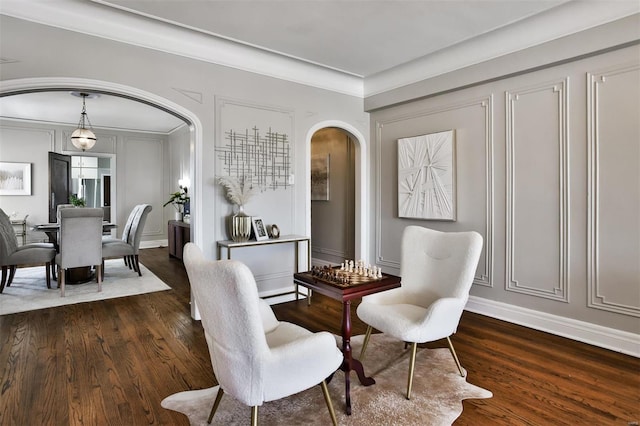 living area featuring ornamental molding and dark hardwood / wood-style flooring