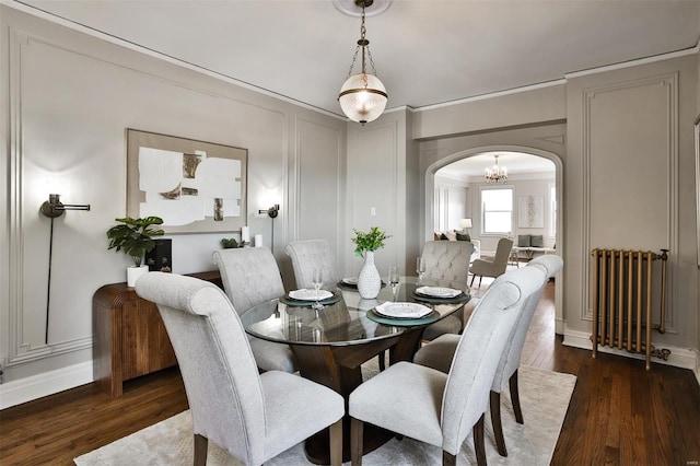 dining room with ornamental molding, dark hardwood / wood-style flooring, and radiator