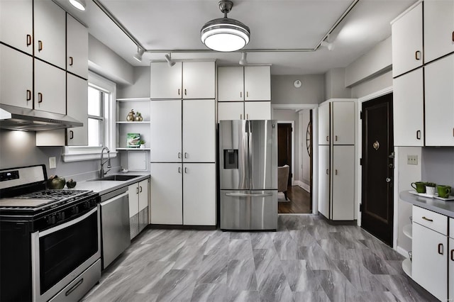 kitchen with stainless steel appliances, under cabinet range hood, white cabinetry, open shelves, and a sink