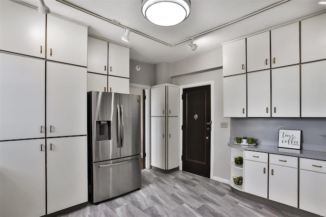 kitchen with rail lighting, stainless steel fridge with ice dispenser, light hardwood / wood-style flooring, and white cabinets