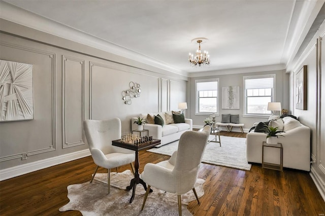 interior space featuring dark wood-type flooring, a decorative wall, baseboards, and an inviting chandelier