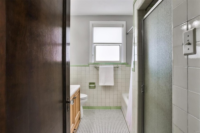 full bath featuring tile walls, toilet, a shower with shower door, vanity, and a tub