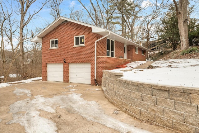 view of snow covered exterior with a garage