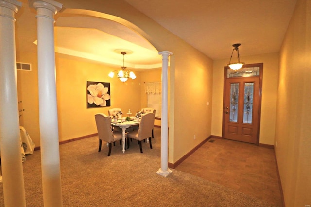 entrance foyer featuring decorative columns, carpet, and a chandelier