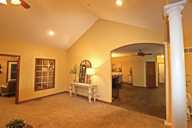 hallway with dark colored carpet, high vaulted ceiling, and decorative columns