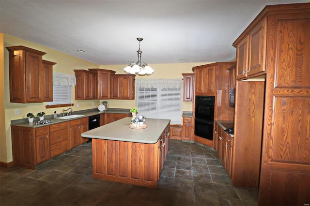 kitchen with black appliances, a kitchen island, decorative light fixtures, sink, and a chandelier