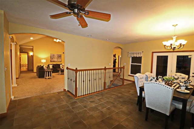 dining room featuring vaulted ceiling, french doors, ceiling fan with notable chandelier, and dark carpet