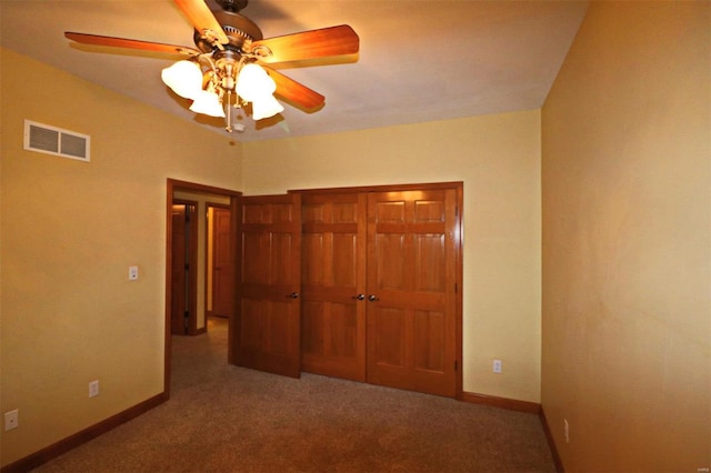 unfurnished bedroom with ceiling fan, carpet, and a closet