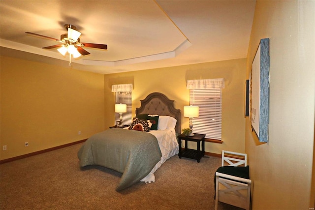 bedroom featuring ceiling fan, carpet flooring, and a raised ceiling