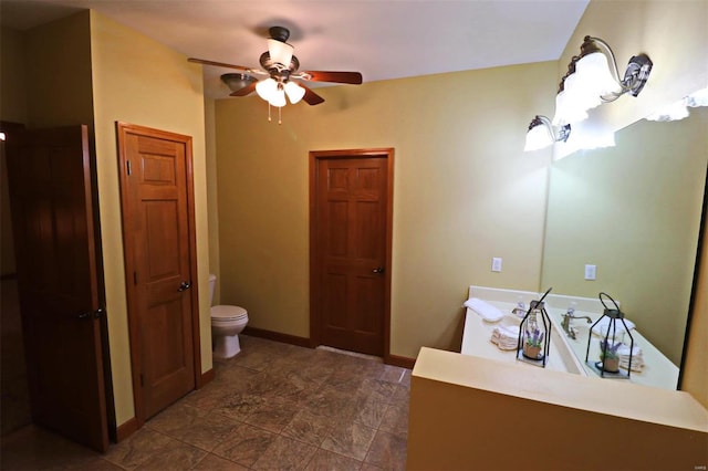 bathroom featuring toilet, vanity, and ceiling fan