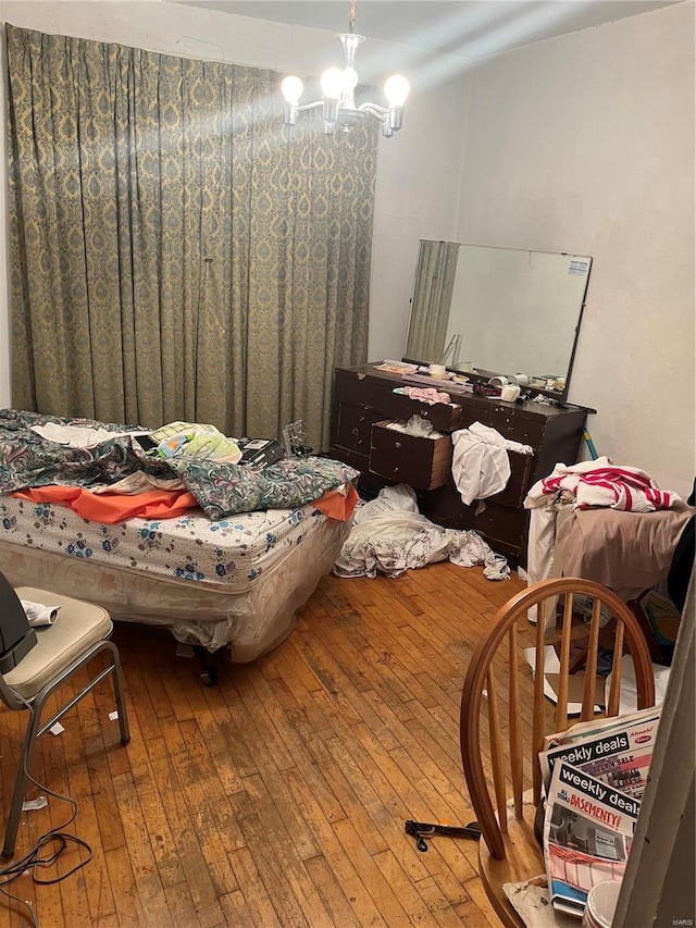 bedroom with a notable chandelier and hardwood / wood-style flooring