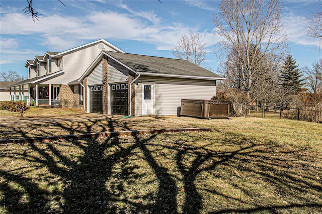 rear view of property featuring a yard and a garage