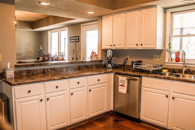 kitchen featuring dark hardwood / wood-style floors, sink, dark stone countertops, white cabinets, and stainless steel dishwasher