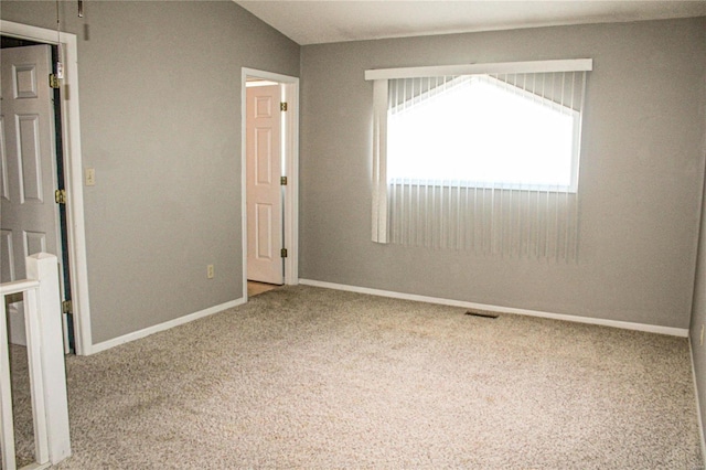 unfurnished bedroom with carpet flooring and vaulted ceiling