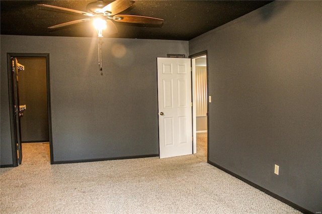 carpeted empty room featuring ceiling fan