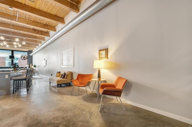 living area featuring wooden ceiling, beam ceiling, and concrete flooring