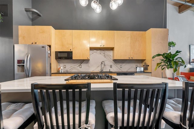 kitchen with stainless steel appliances, light brown cabinets, tasteful backsplash, light stone countertops, and sink