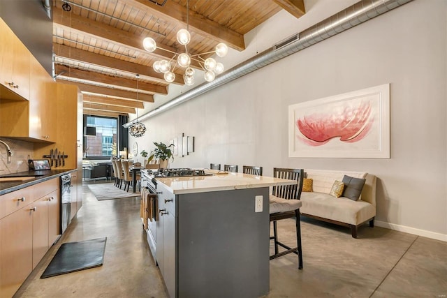 kitchen featuring stainless steel range with gas cooktop, wooden ceiling, decorative light fixtures, a kitchen island, and beamed ceiling